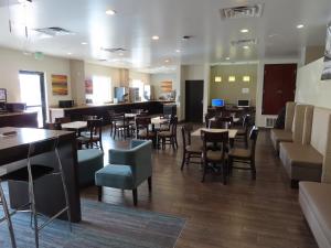 a restaurant with tables and chairs and a bar at Sleep Inn & Suites Denver International Airport in Denver
