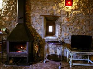 a stone room with a fireplace and a television at Belvilla by OYO Can Guilella in Montmajor