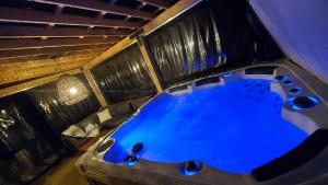 a large blue tub in a room with a couch at Le Chalet Suisse in Mont-Blanc