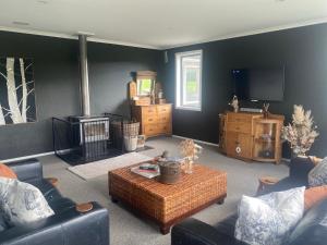 a living room with a couch and a coffee table at Tomogalak Lodge in Lumsden