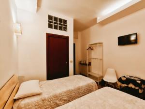 a room with two beds and a door and a chair at B&B "Le Corti" in Turate