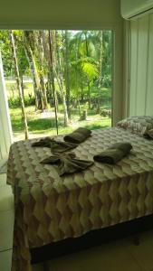 a bed in a bedroom with a large window at Vila Contêiner - 900 m do centro in Morretes