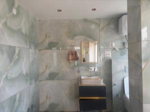 a bathroom with a sink and a mirror at Anayah B and B in Shimla