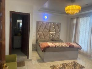 a bedroom with a large bed and a chandelier at Anayah B and B in Shimla