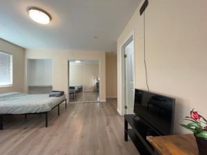 a living room with a bed and a flat screen tv at The Disney Hostel - Santa Ana in Santa Ana