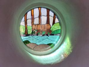 a round stained glass window with a bear in the water at The Roundhouses in Cygnet