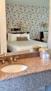 baño con lavabo, cama y espejo en Lewis River Inn, en Woodland