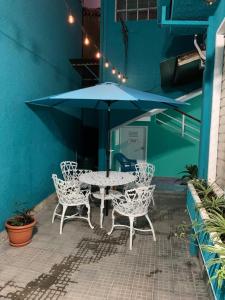 a table and chairs with an umbrella on a patio at Hostal primaveras nest centro santa ana in Santa Ana