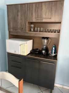 a kitchen counter with a microwave and a blender at Apartamento Centro de Alfenas! in Alfenas +9 photos