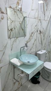un baño con lavabo e inodoro en Loft Onofre, en Cabo Frío
