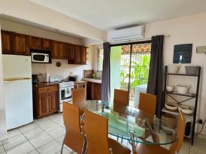 a kitchen with a glass table and chairs in it at Pineapple Condo at Villa Riviera in Coco