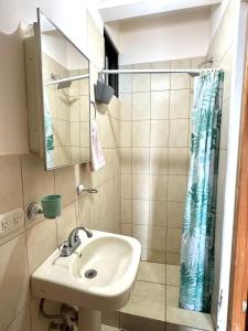 a bathroom with a sink and a shower curtain at Pineapple Condo at Villa Riviera in Coco +30 photos