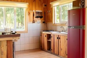 a kitchen with wooden cabinets and a red refrigerator at Parque Vera Cabaña 1 in Melipeuco +13 photos