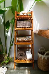 a wooden shelf with towels on it next to a plant at Beachfront Luxury Dome Villas - Gamat Bay Resort in Nusa Penida +43 photos