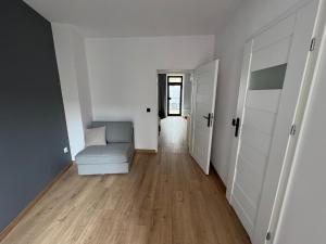 a living room with a couch and a hallway at Guben Wohnungen apartament in Guben