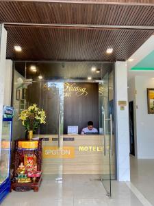 a store front with a man sitting in the window at Mộc Hương Residences & Herb in Hue