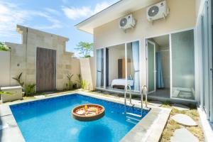 a villa with a pool and a bedroom at Otia Villa Nusa Dua by Premier Hospitality Asia in Nusa Dua