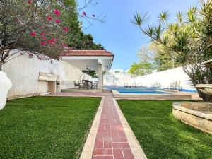 a house with a garden and a swimming pool at Alojamiento para 3 personas en Casa Alpha in Mérida