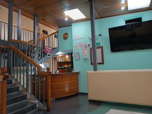 a lobby with a staircase and a flat screen tv at Hostal Your Home in Quito
