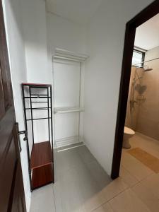 a bathroom with a toilet and a shelf in a room at Villa Tres Adam in Canggu
