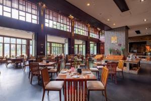 三亚Stony Brook Villa Jianguo Resort Sanya的餐厅设有木桌、椅子和窗户。