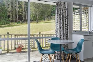 eine Küche mit einem Tisch und Stühlen vor einem Fenster in der Unterkunft Roselle Farm Cottage in Portobello + 25 Fotos