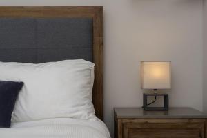 ein Schlafzimmer mit einem Bett mit einer Lampe auf einem Nachttisch in der Unterkunft Roselle Farm Cottage in Portobello