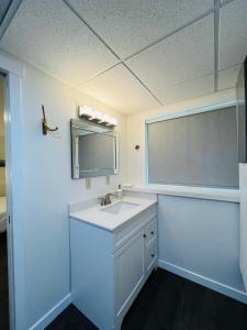 a white bathroom with a sink and a window at Beautiful home with one acre land for leisure time in Vancouver Island in Nanaimo