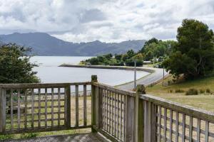 einen Holzzaun mit Seeblick in der Unterkunft Roselle Farm Cottage in Portobello