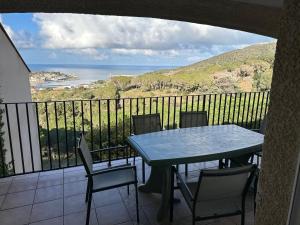 a table and chairs on a balcony with a view of the ocean at Maison Familiale sur la Côte Vermeille avec Climatisation et WIFI - FR-1-309-497 in Port-Vendres