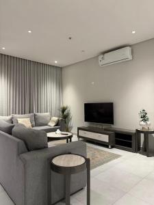 a living room with a couch and a flat screen tv at شقة حديثة مودرن 3 غرف وصالة a9 in Riyadh +32 photos