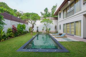a backyard with a swimming pool and a house at Villa Dampati in Sanur +8 photos