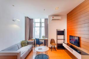 a living room with a couch and a tv and a table at Dua Sentral Residence near KL Sentral by COBNB in Kuala Lumpur