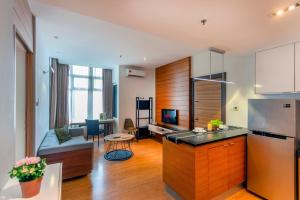 a living room with a kitchen and a living room with a couch at Dua Sentral Residence near KL Sentral by COBNB in Kuala Lumpur
