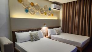 two beds in a hotel room with at Nazville vacation home in Pasig