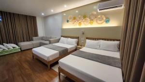 a hotel room with two beds and a couch at Nazville vacation home in Pasig