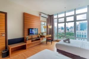 a hotel room with a bed and a desk with a television at Dua Sentral Residence near KL Sentral by COBNB in Kuala Lumpur +103 photos