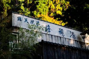 a wall with chinese writing on it at くらま温泉 in Kyoto