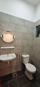a bathroom with a toilet and a sink and a mirror at Ipoh Meru Landed Homestay TropiCasa 28 in Ipoh +22 photos