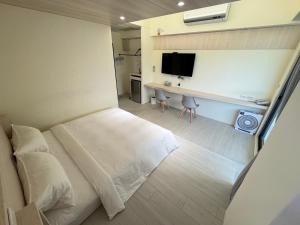 a small bedroom with a bed and a desk at Yin Yun Slow Travel B&B 吟雲慢旅 in Fu-wen-ts'un