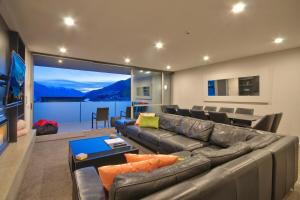 Una sala de estar con un sofá y una ventana grande. en Beeches - Downtown Queenstown in Luxury, en Queenstown