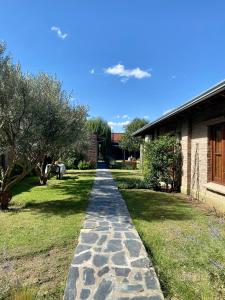 a stone path in a yard next to a house at Casitas El Lago in Carhué