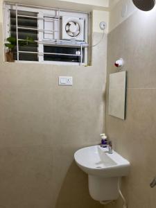 un bagno con un lavandino bianco e una finestra di Gachibowli ' House of Color's Susi Stays-303 1 BHK a Gachibowli