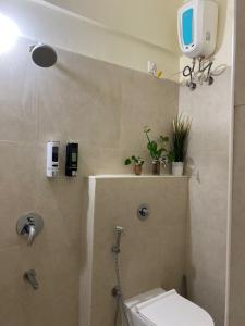un bagno con un water e una tv a parete di Gachibowli ' House of Color's Susi Stays-303 1 BHK a Gachibowli
