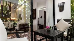 a balcony with a wooden table and a bench at Lynnaya Urban River Resort in Siem Reap