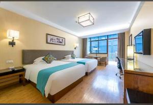 a hotel room with two beds and a desk at SSAW Boutique Hotel Hangzhou Qiandao Lake in Chun'an