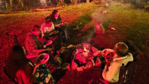 Casspo Forest Bungalow في Kallar Vattiyar: مجموعة من الناس يجلسون حول النار المخيم