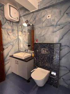 a bathroom with a toilet and a sink and a tv at 4bhk-Villa at dlf valley township Panchkula in Panchkula