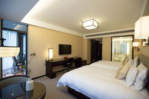 a hotel room with a large bed and a desk at SSAW Boutique Hotel Hangzhou Qiandao Lake in Chun'an