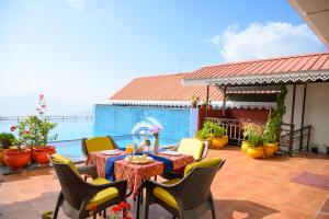 een patio met een tafel en stoelen en het water bij Sinclairs Gangtok in Gangtok